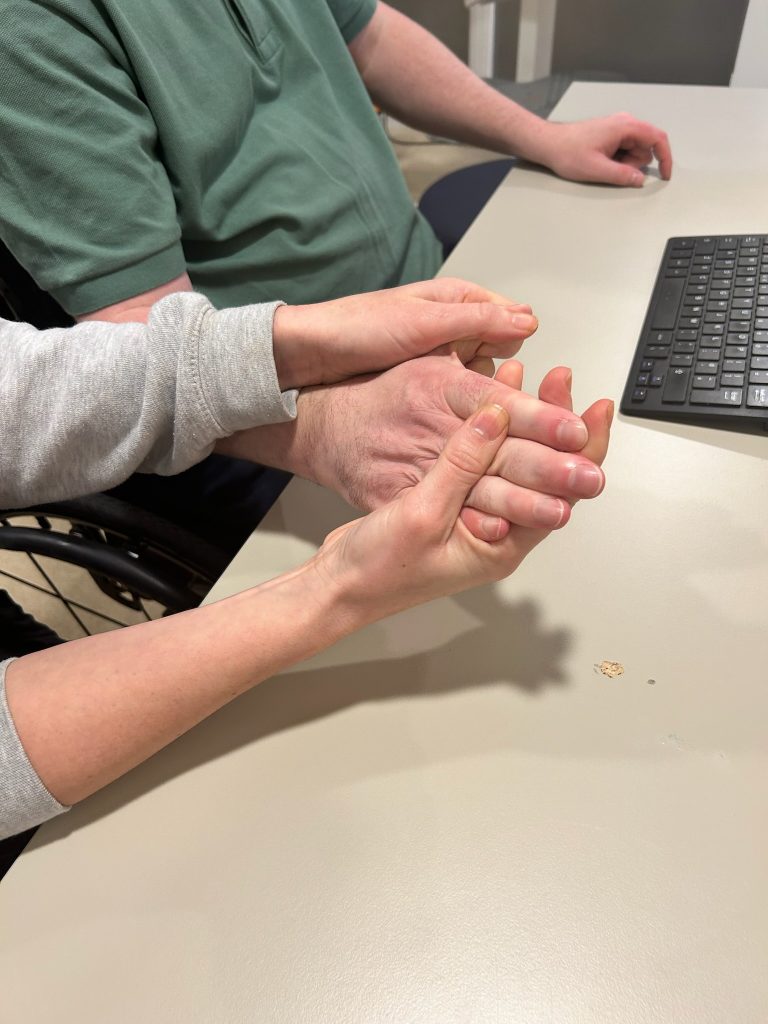 close up of right hand being stretch by two hands of a physiotherapist