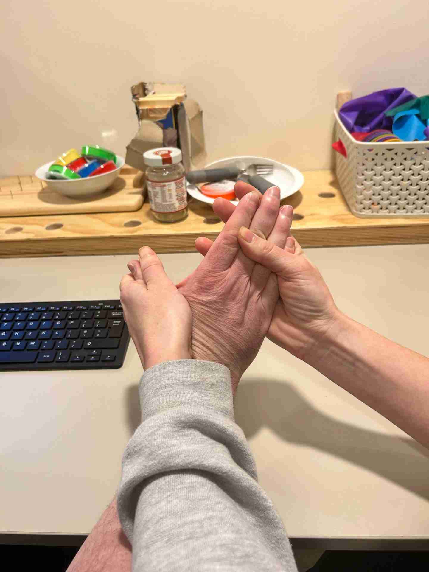 A specialist using a hands-on therapy technique on a persons hand to aim to reduce Spasticity
