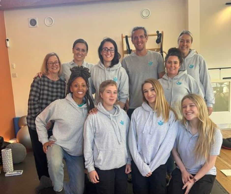 Team photo of 10 members of staff wearing their vim jumpers smiling at the camera